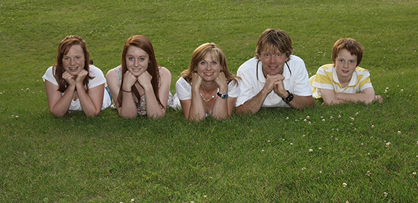 family of 5 sitting on grass