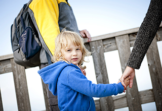 girl walking and holding her parents hands