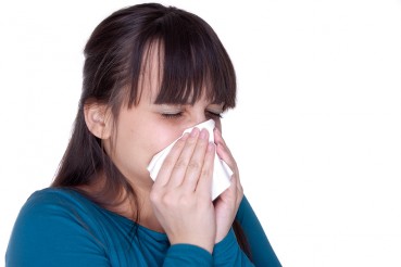 Woman blowing her nose in tissue