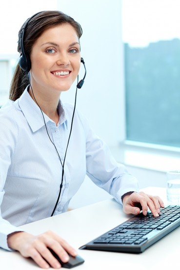 women with headphones transcribing on a computer